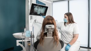 Dental professional showing a female patient an X-ray.