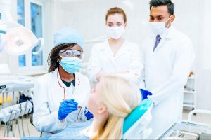 A team of dentists working with a patient.