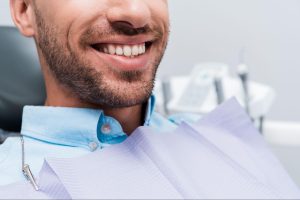 Man smiling in a dental exam chair.