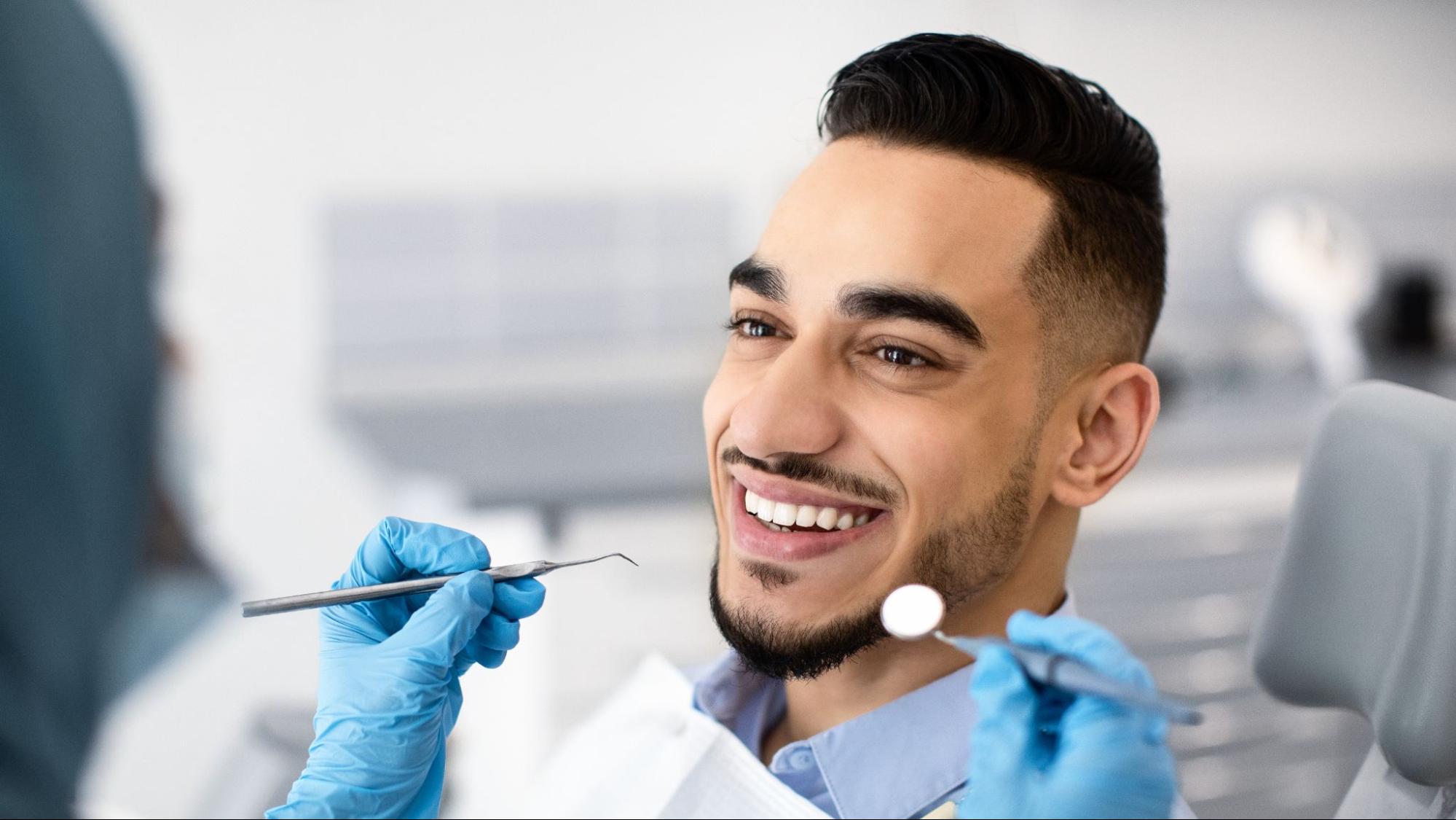 Man smiling in a dental exam chair.