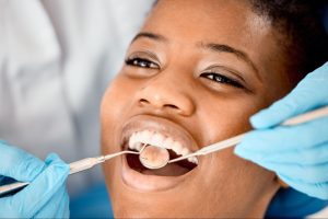 A woman undergoing dental deep cleaning at a clinic.