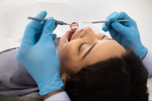 A female patient receiving dental care in a treatment chair.