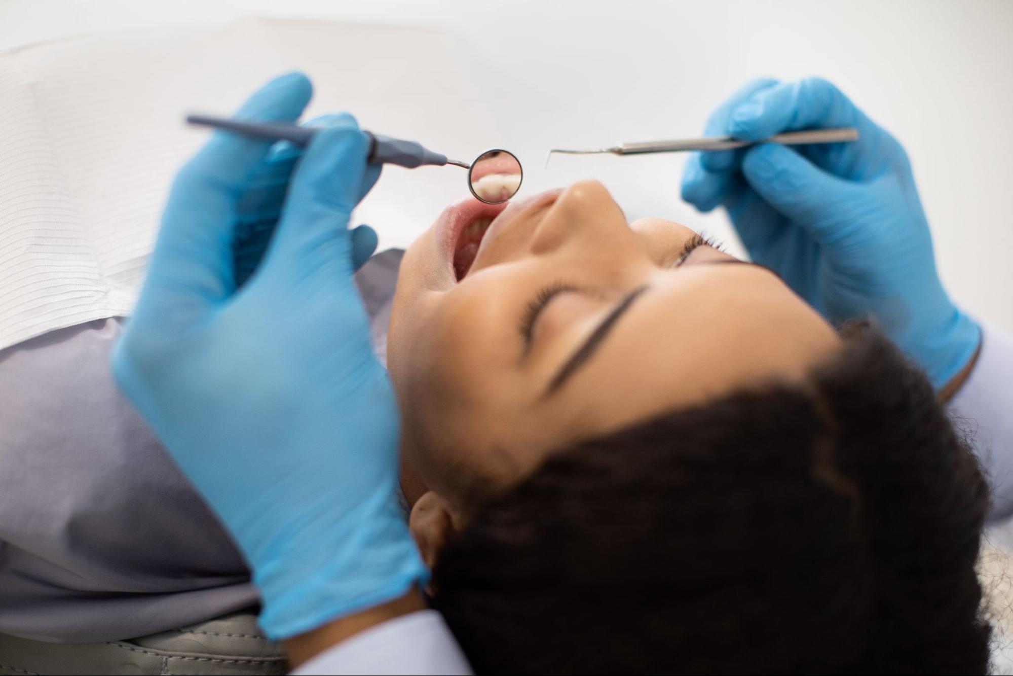 A female patient receiving dental care in a treatment chair.